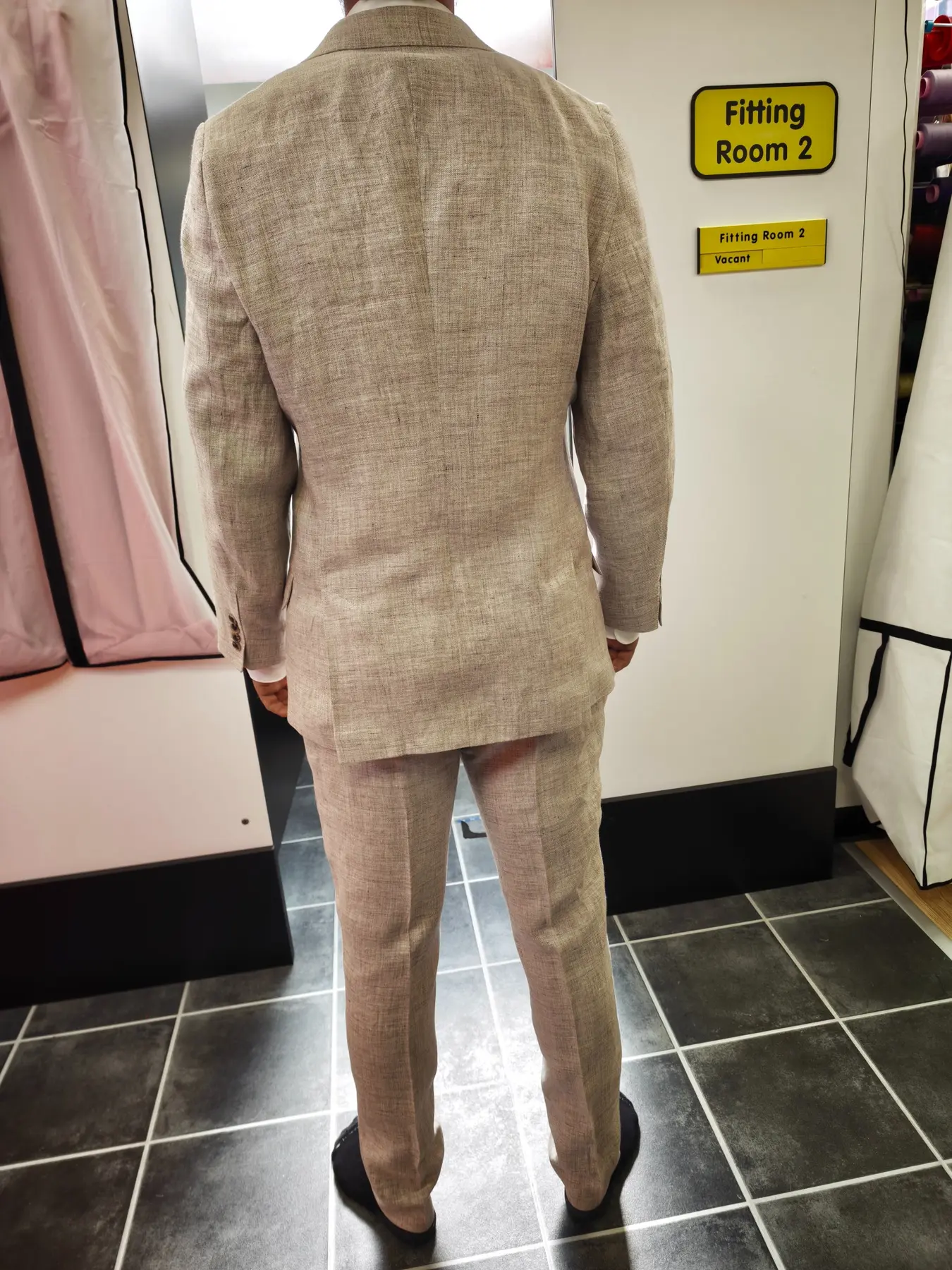 The finished back fit of a neutral linen suit